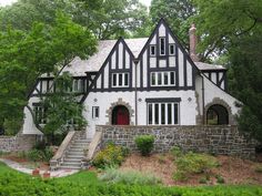 a large white and black house surrounded by trees