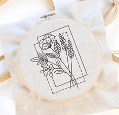 a cross stitch pattern with flowers and leaves on the front is shown in black ink