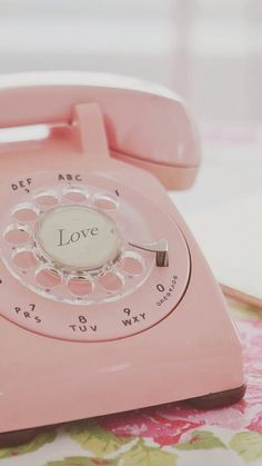 an old pink phone with the word love on it