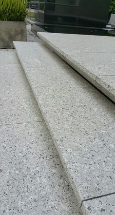 a close up view of some concrete steps with plants in the backgroung