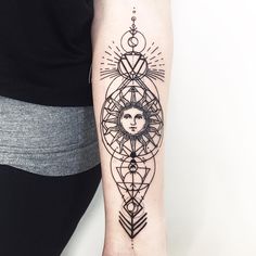 a woman's arm with a sun and moon tattoo design on the left forearm