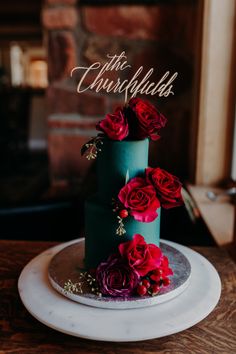 a three tiered cake with red flowers on top and the words the churkflub above it