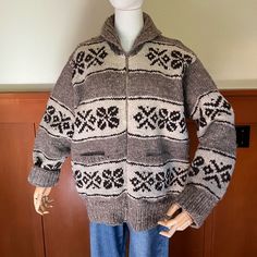 a mannequin wearing a sweater and jeans in front of a wooden paneled wall