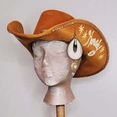 Let your accessories do the talking in the Howdy Padna! Folded Chain Cowboy Hat Hat is made from sueded felt material with custom band from an upcycled vintage gold  pin and chain necklace. Gold chain around folded brim with hand painted details and custom made pendant from vintage jewelry. Hat Measures: Crown: 22 inches Length (front to back): 15 inches Width (left to right): 14inches **measurements for size/shipping purposes** All pieces made are 1/1 and cannot be replicated Custom Requests are available with a 2 week max turnaround time Follow Rhinestone_Bullet on IG for sneak previews of shop listings Necklace Gold Chain, Chapeau Cowboy, Chain Necklace Gold, Gold Pin, Felt Material, Floral Denim, Upcycled Vintage, Cowboy Hat, Necklace Gold