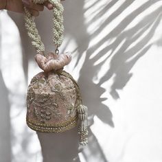 Indulge in timeless elegance with our exquisite bridal potli bag, meticulously crafted on blush pink velvet to capture the essence of luxury and tradition. Designed with South Indian brides in mind, this opulent accessory is adorned with intricate dabka, beadwork, sparkling stones, and shimmering sequins, ensuring a mesmerizing entrance on your special day. Elevate your bridal ensemble with this stunning potli bag, a symbol of sophistication and grace. Product Details: *Handmade with traditional Pakistani and Indian techniques *Spacious interior  *Measures 6 inches To explore additional styles, kindly visit our website at dulhansdiary.etsy.com. . . . . . . #silverpotlibag #handmadeclutch #bridalhandbag #weddingaccessories #ethnicbag #uniquegift #artisanmadeclutch #punjabiclutches #potlibag Traditional Pink Shoulder Bag For Evening, Elegant Potli Bag With Pearl Handle, Elegant Pink Embroidered Potli Bag, Gold Potli Bag With Pearl Handle For Wedding, Elegant Pearl Embroidery Potli Bag For Formal Occasions, Elegant Pink Potli Bag For Gift, Traditional Pink Bag For Reception, Elegant Bags With Pearl Handle For Reception, Luxury Beige Shoulder Bag For Wedding