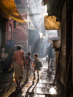 people walking down an alley way in the rain