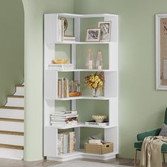 a white book shelf in the corner of a living room with stairs leading up to it