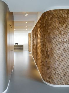 an empty hallway with wooden walls and white flooring in the center, leading to a reception area