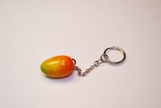 a keychain with a piece of fruit hanging from it's side on a white surface