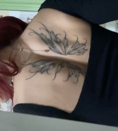 a woman with red hair and tattoos on her stomach is looking down at the camera