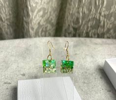 Make a fashion statement with our stunning Lightweight Resin Square earrings. These eye-catching dangle earrings are designed to impress and add a touch of elegance to any outfit. Handmade with love in beautiful British Columbia, our earrings reflect the creativity and craftsmanship that the region is renowned for. Each piece is infused with the spirit of the stunning surroundings, ensuring a touch of elegance and natural beauty. Don't miss out on owning a pair of these Lightweight Resin Square earrings. Treat yourself or surprise a loved one with a thoughtful gift. Elevate your style and showcase your impeccable taste with these exquisite handmade earrings. Note: Due to the handcrafted nature of the earrings, slight variations in color and pattern may occur, making each pair a wearable wo Green Drop Earrings For Anniversary, Modern Green Earrings As Gift, Modern Green Drop Earrings, Hypoallergenic Green Jewelry For Parties, Green Drop Earrings As Gift, Modern Green Dangle Earrings, Modern Green Earrings For Anniversary, Green Rectangular Earrings, Rectangular Green Earrings Gift