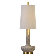 a table lamp with a white shade on it and a gold frame around the base