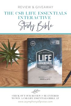 a book and pen sitting on top of a wooden table next to a potted plant