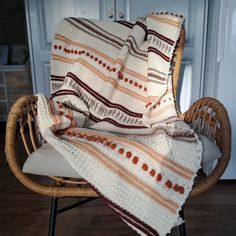 a chair with a blanket on top of it in front of a cabinet and door