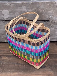 a multicolored basket sitting on top of a wooden floor