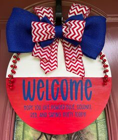 a door hanger with a welcome sign and red white and blue bow on it