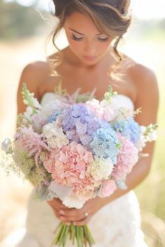 a woman holding a bouquet of flowers in her hands