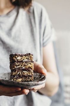 a woman holding a plate with two pieces of cake on it and one slice missing