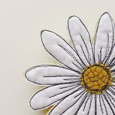 a white flower with yellow center sitting on top of a table