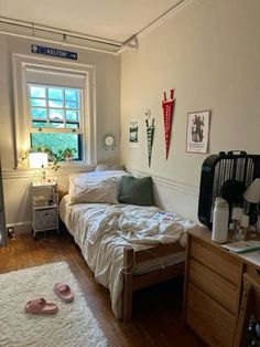 a bed room with a neatly made bed next to a window and a rug on the floor