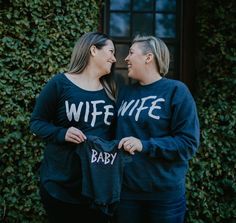 two women standing next to each other with their arms around one another and the words wife baby printed on them