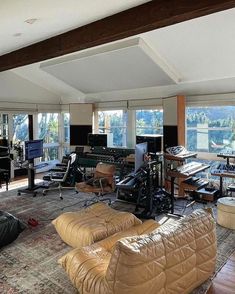 a living room filled with lots of furniture and large windows overlooking the water in front of it