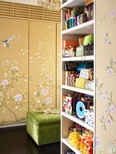 the closet is decorated with flowers and birds on the wall, along with a green ottoman