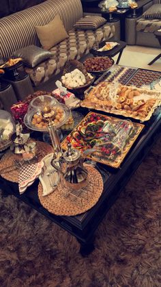 a table filled with lots of food on top of a brown carpeted room floor