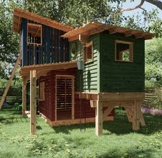 a small green and red house in the middle of some grass with a ladder up to it's roof