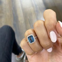 a woman's hand with a ring on it and a blue stone in the middle