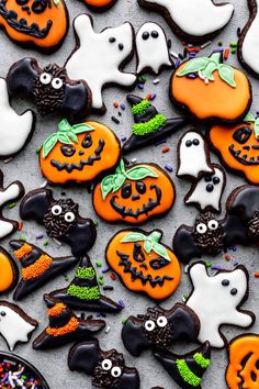 halloween cookies decorated with icing and sprinkles are arranged on a table