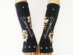 Exclusive item designed by Käoshee.  K'67 Long Gloves, Arm warmers. Handmade, unique & exclusive. Very comfortable, the glove adapts perfectly to the shape of the arm due to its curved pattern. Made of high quality polyester  with a fantastic leopard imitation fabric in polyester. Functional YKK zipper and sealed nickel studs.  Universal size since polyester has good stretching ability.  It is recommended to lower the zipper before putting on and taking off the glove, especially in bigger arms.  Handwash 30o Max. Measures 25 cms x 9,5 cms. Punk gloves, punk clothing, emo clothing, harajuku wear, visual kei, gothic gloves, tartan gloves, kawaii, manga, leopard Black Harajuku Leg Warmers For Fall, Black Harajuku Style Leg Warmers For Fall, Punk Style Winter Leg Warmers For Streetwear, Harajuku Style Black Leg Warmers For Fall, Black Fitted Harajuku Leg Warmers, Harajuku Style Black Leg Warmers For Winter, Alternative Style Black Leg Warmers For Winter, Black Edgy Leg Warmers For Cosplay, Black Stretch Leg Warmers For Cosplay