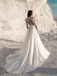 a woman wearing a wedding dress standing in the snow