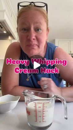 a woman sitting at a table with a measuring cup in front of her and the words heavy whipping cream hack