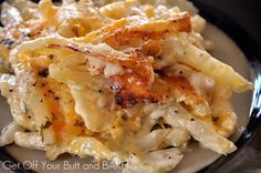 pasta with chicken and cheese is served on a black rimmed plate, ready to be eaten