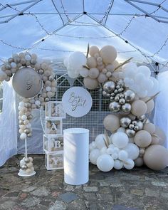 balloons and decorations are set up under a tent for a baby shower or birthday party