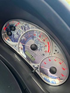 three speedometers on the dashboard of a car