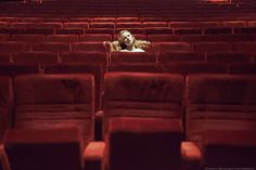 a woman is sitting in an empty theater