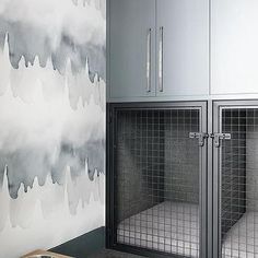 a dog kennel in front of a wall with clouds painted on it and a wooden table