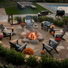 an outdoor fire pit with chairs around it