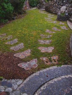 an outdoor area with stepping stones and grass