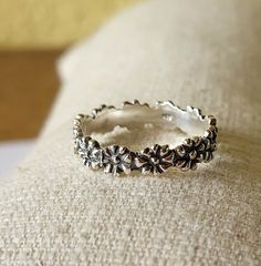 This beautiful ring with small flowers is an absolute eye-catcher. It is a highlight both individually and in combination with other stacking rings. The individual flowers are firmly soldered together, making it very stable. - Material: 925 sterling silver - Size of the flowers: approx. 4 mm - partially oxidized - solid and stable, therefore no bending If you have any questions, please send me an email and I'll get back to you, I promise. Delicate Stackable Flower Ring, Adjustable Silver Daisy-shaped Jewelry, Adjustable Silver Daisy Jewelry, Silver Delicate Flower Shaped Ring, Delicate Silver Flower-shaped Ring, Delicate Silver Ring With Flower Shape, Silver Flower Rings With Adjustable Fit, Dainty Handmade Silver Flower Ring, Handmade Delicate Stackable Rings