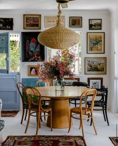 a dining room table with chairs and a fan hanging from the ceiling in front of it