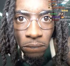 a man with glasses and dreadlocks is looking at the camera while wearing eyeglasses