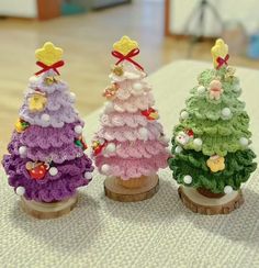 three small crocheted christmas trees sitting on top of a table