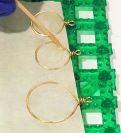 a pair of glasses sitting on top of a piece of green plastic with a wooden handle