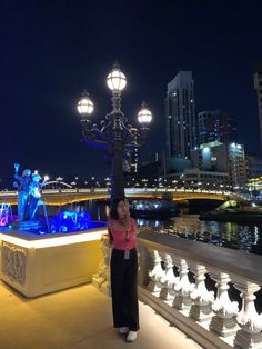 a woman taking a selfie in front of the river at night with lights on