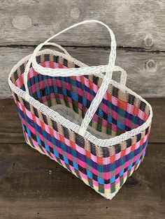 a multicolored basket sitting on top of a wooden table