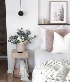 a white bed with pillows and blankets on it