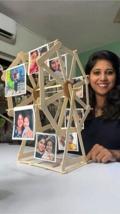 a woman standing next to a table with pictures on it and a ferris wheel in front of her